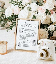 a table with flowers and a sign that says load new film next to a camera