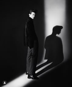 a man standing in front of a shadow on the wall