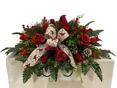 a white box with red roses and greenery