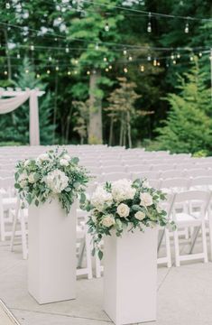 two white vases filled with flowers on top of a table