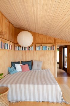 a bed sitting in the middle of a bedroom next to a book shelf filled with books