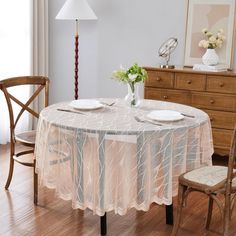 a dining room table with two chairs and a lamp