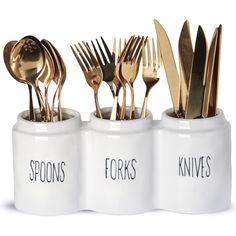 gold forks and spoons are in white containers with black lettering on the sides that read spoons knives