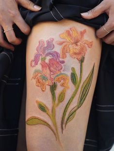 a woman's thigh with flowers painted on it