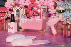 a pink bathroom decorated with balloons and other items on the floor in front of a stage set