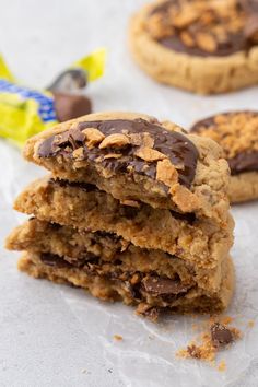 two chocolate chip cookies stacked on top of each other with one broken cookie in the middle