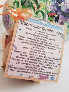 a sign that says supervisor survival kit in front of a vase with flowers and other items