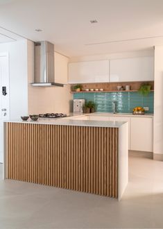 a kitchen with an island and stove top oven next to a wall mounted range hood