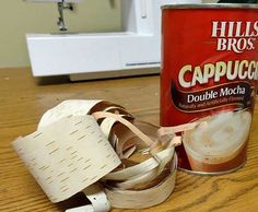 a can of cappuccino sitting on top of a table next to some tape