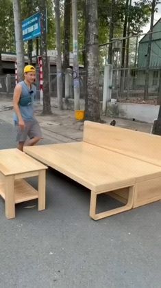 a man walking past a wooden bench on the street