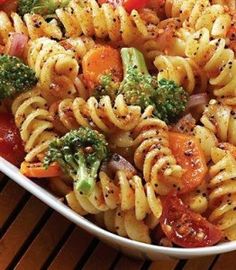 pasta with tomatoes, broccoli and onions in a white bowl