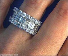 a woman's wedding ring with three baguettes on it and two rows of diamonds