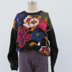 90s oversized fit floral sweater with tons of cottagecore flair. 55/45 cotton ramie blend. Colors: black background with marigold, rust, purple, fuchsia, cream, burgundy, olive, sage, teal, forest green, and so on and so forth. It's a beauty. Made in Hong Kong for C H U  Label size M Measurements taken flat, unstretched, with moderate stretch available Please compare measurements to a similar garment that fits you well 23" shoulder to shoulder 23" pit to pit 27-1/2" top to bottom  21-1/2" sleeve 90s Cottagecore, Style Cottage, Floral Sweater, H U, Flower Detail, Crochet Flower, Fitted Sweater, Jumpers And Cardigans, Crochet Flowers