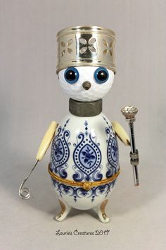 a small figurine with a crown on it's head holding a key