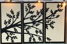 three panels with black branches and lights on them