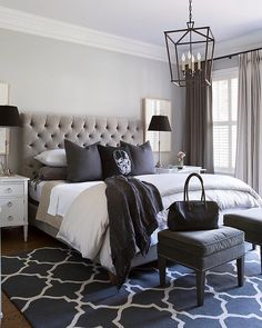 a bedroom with a bed, chair and chandelier