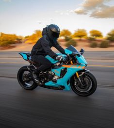 a man riding on the back of a blue motorcycle