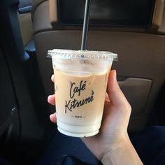 a person holding up a cup with a straw in it and the words cafe kreme written on it