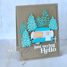 a handmade card with a camper and pine trees on the side that says just saying hello