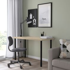 a laptop computer sitting on top of a desk next to a chair in front of a window