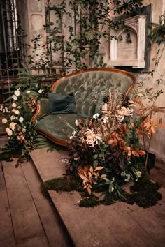 an old couch with flowers and greenery on the floor