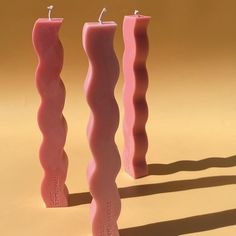 three pink candles sitting next to each other on a table