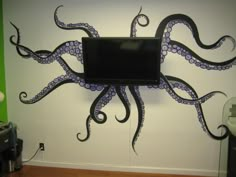 an octopus wall mounted to the side of a white wall with a computer monitor on it