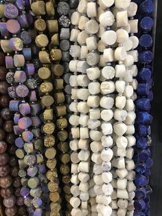 many different colored beads are hanging on the wall