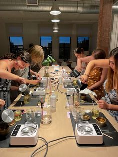 a group of people standing around a table with plates and bowls on top of it