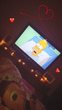 the simpsons is watching tv in bed with hearts on the wall behind him and his stuffed animal