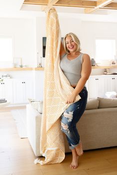 a woman is holding up a blanket in her living room