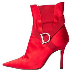 Dating to the early 2000's, these Christian Dior ankle boots are made from glossy red satin with elastic accents and a crystal D logo on the side of the foot, and also feature a pointed toe & four inch stiletto heel. Made in Italy, these were designed by John Galliano during his tenure as creative director of the luxury house. Size: 38.5 Condition: Excellent/Very Good; minor signs of wear to satin including very light grazing around the toes & heels in a few places; some minor wear to soles 2010 Heels, Dior Clothing, D Logo, Fantasy Wardrobe, 20th Century Fashion, Italian Shoes, Shopping Photography, Maasai, John Galliano