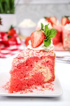 a slice of strawberry cake on a plate with strawberries and whipped cream in the background