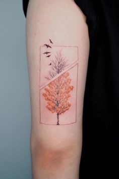 a woman's arm with an orange tree and birds on the left side of her arm