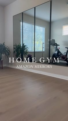 an empty living room with mirrors on the wall and a bike in front of it