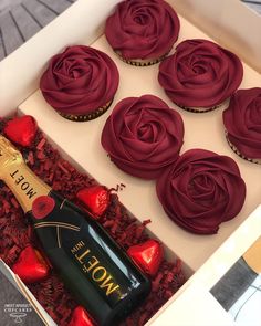 a box filled with cupcakes and a bottle of champagne