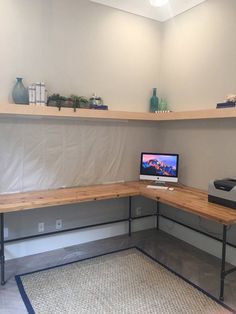 a laptop computer sitting on top of a wooden desk next to a printer and monitor