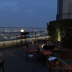 an outdoor dining area overlooking the city at night