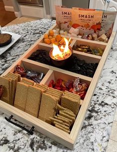 an open wooden box filled with snacks on top of a counter