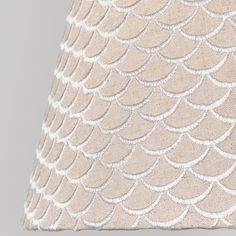 a beige lamp shade with white scales on it