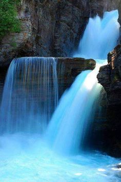 a waterfall with blue water flowing down it's sides