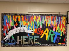 a bulletin board that says creativity starts here and is decorated with colorful streamers on it