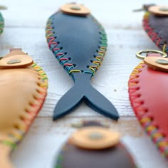 several different colored leather fish ornaments on a table