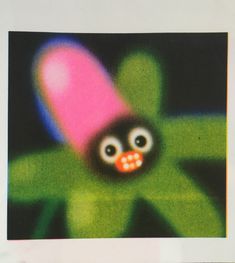 a close up of an odd looking object on a black background with green and pink colors