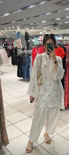 a woman taking a selfie in a clothing store