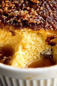 a close up of a cake in a bowl with syrup on it and pecans around the edges