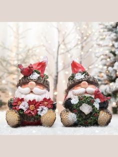 two santa claus figurines sitting in the snow