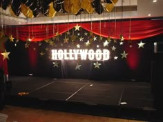 the hollywood sign is lit up on stage with stars hanging from it's ceiling