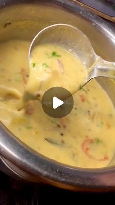 a ladle full of soup being stirred by a spoon