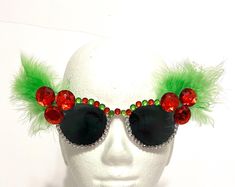 It's holiday time, so make merry with fun Christmas Sunglasses!  These child size white sunglasses have red rhinestones for holly and green feathers for leaves.  The top is covered in large red, green and clear rhinestones, and the bottom in clear rhinestones. Merry Christmas and Happy Holidays  Thank you for visiting my shop! Christmas Sunglasses, Green Feathers, Merry Christmas And Happy Holidays, White Sunglasses, Christmas Holly, Fun Christmas, Red Rhinestone, Holiday Time, Jewelry Boxes